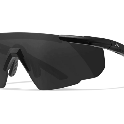 Black wrap-around shield sunglasses with a dark tinted lens and a small white logo on the temple arm, shown on a clean white background.